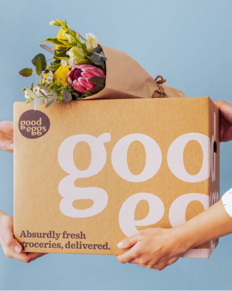 hands carrying a GoodEggs box